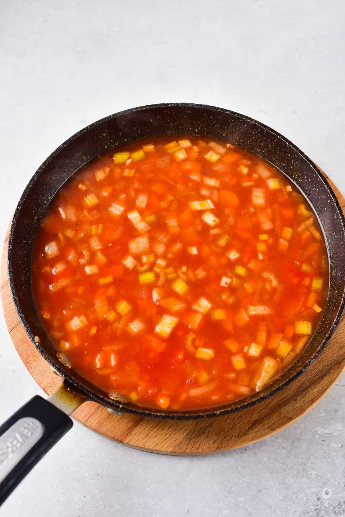 Adding broth to veggie mixture.