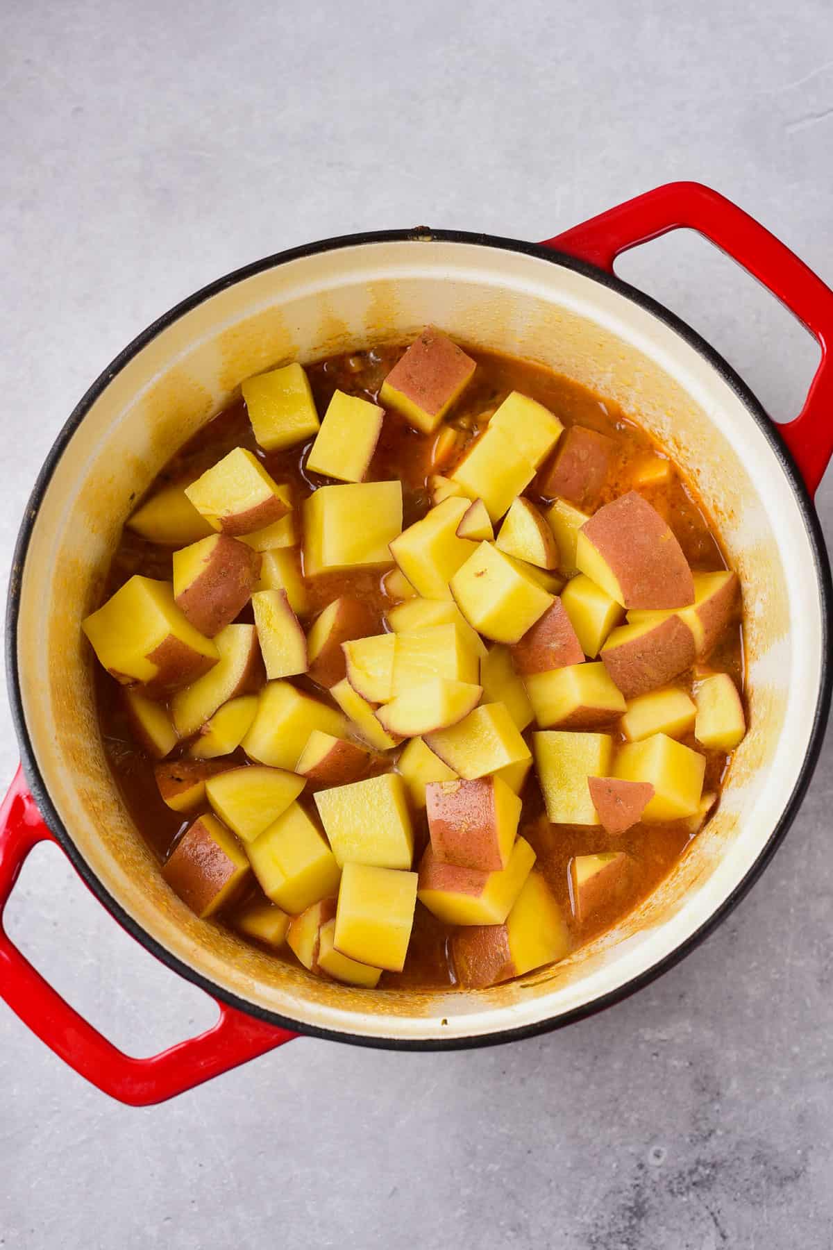 Adding potatoes to to make venison stew.