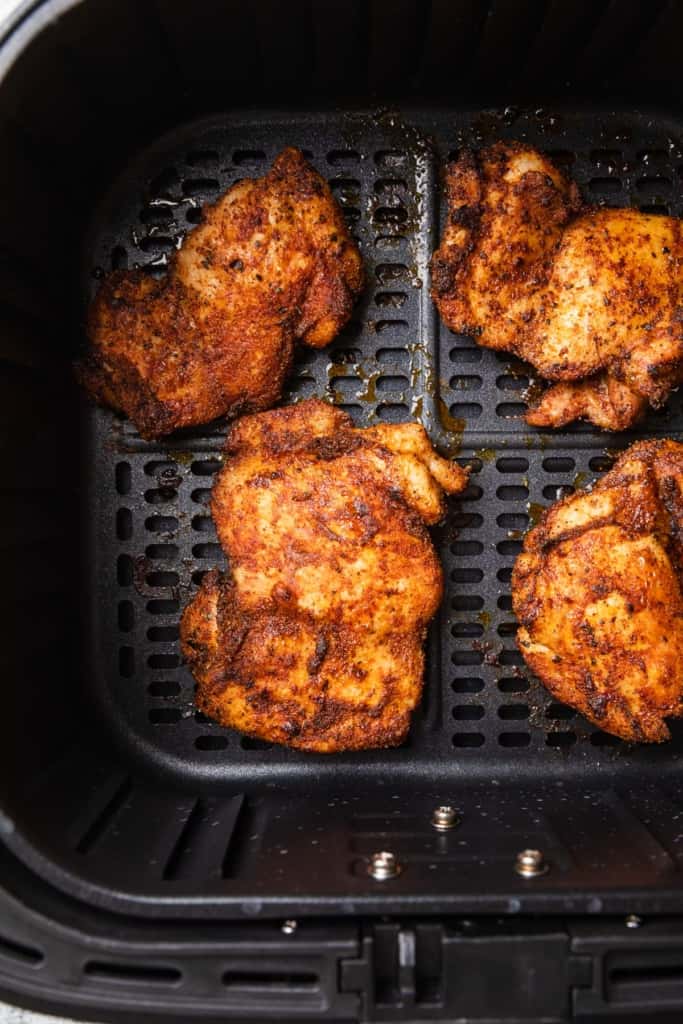 Cooked chicken in the air fryer basket.