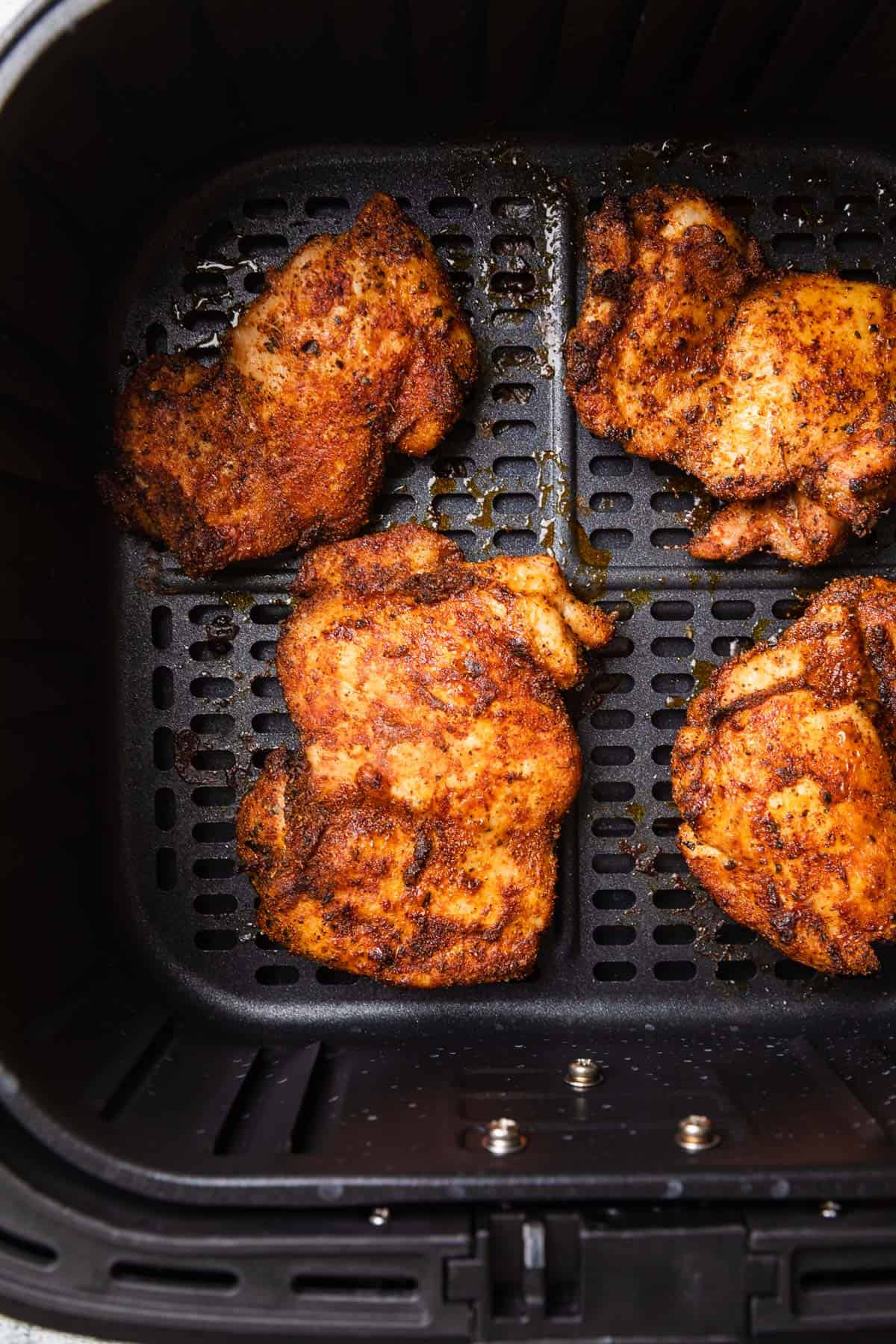 Cooked chicken in the air fryer basket.