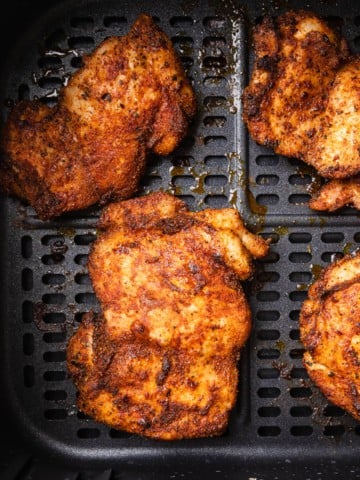 The completed air fryer boneless chicken thighs recipe in the air fryer basket.