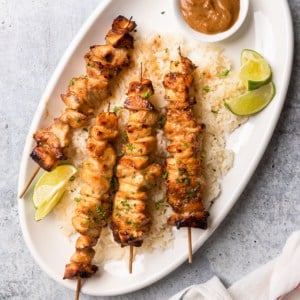 The completed Chinese chicken on a stick recipe on a platter with jasmine rice.