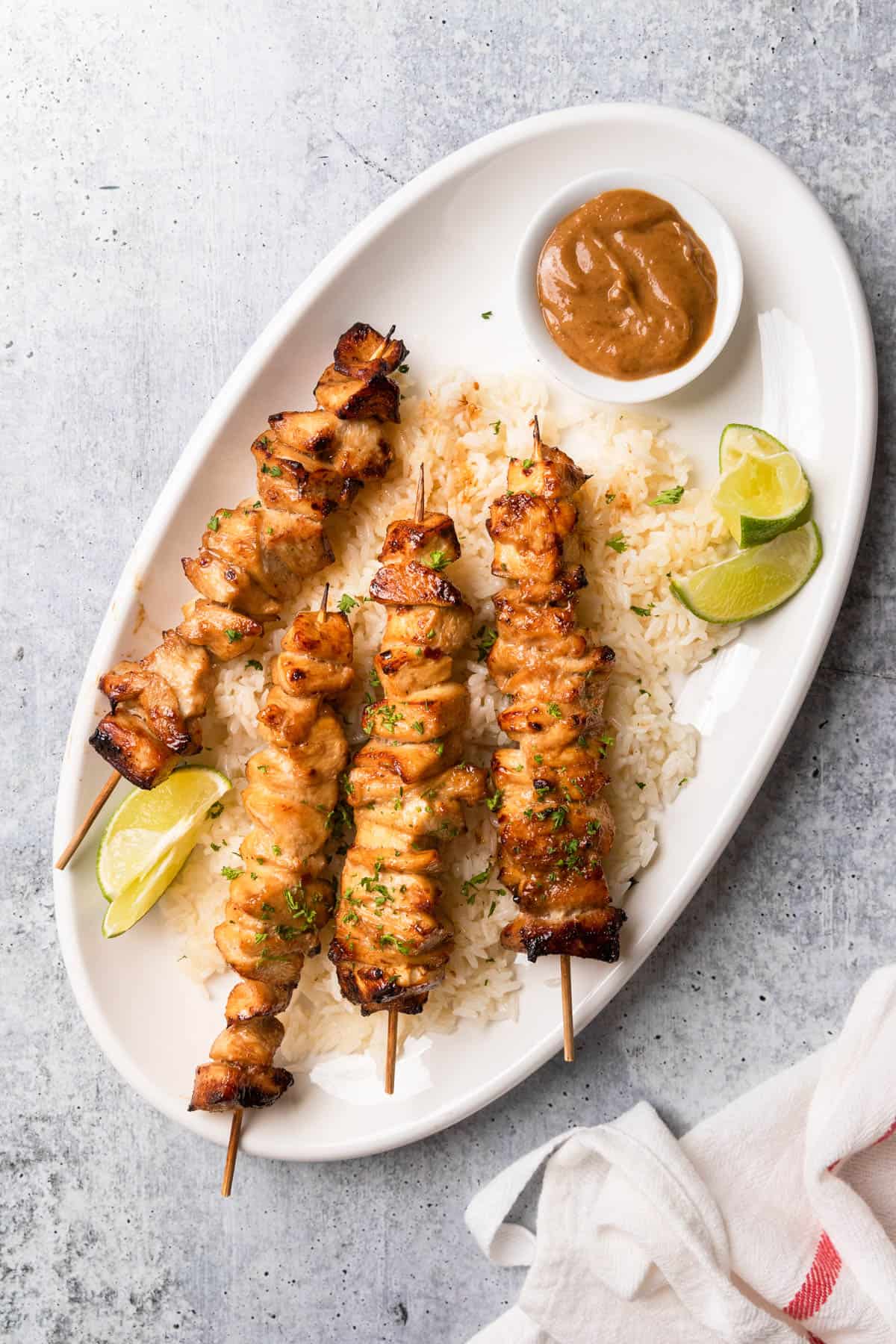 Four Chinese chicken on a stick over a bed of rice.