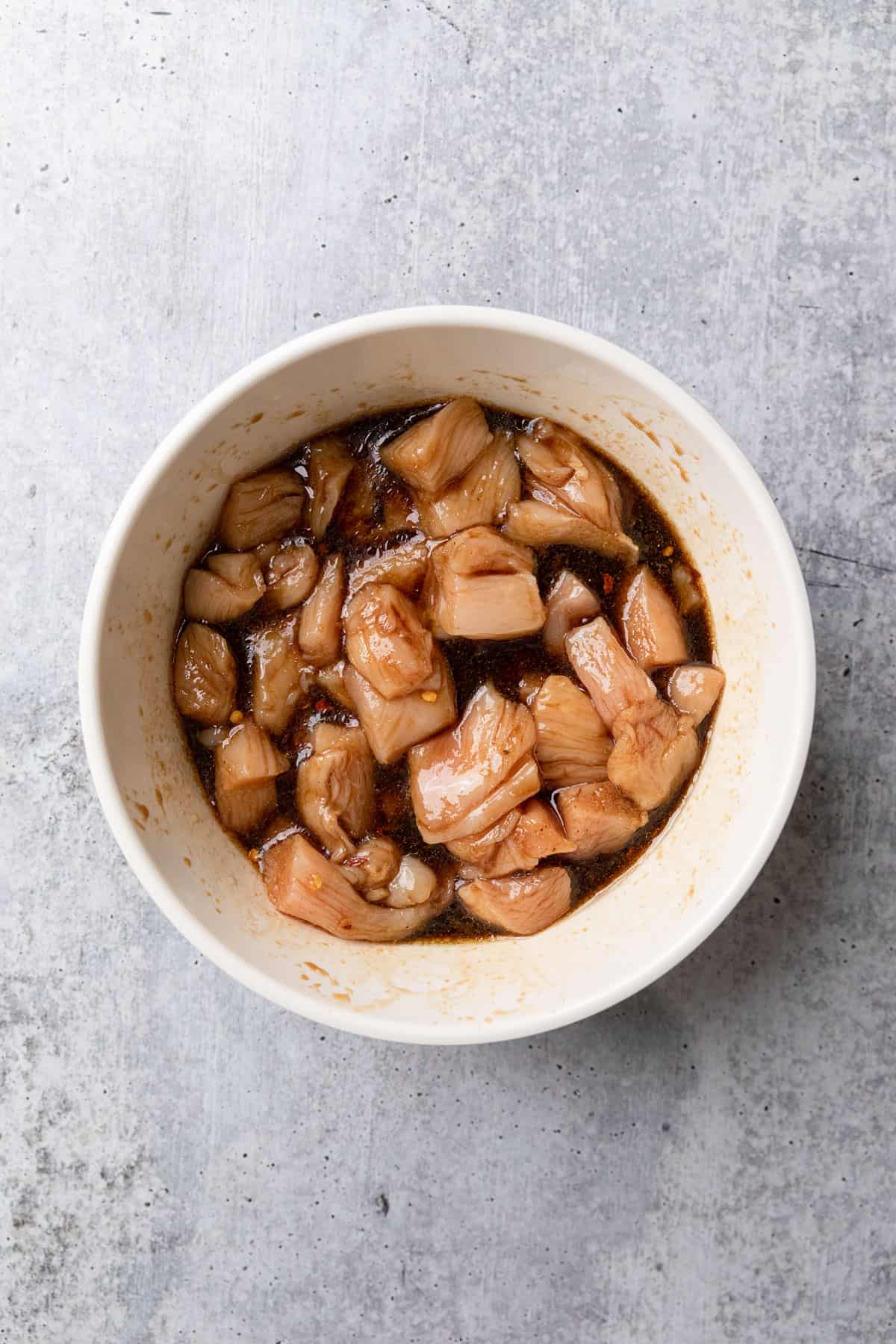 Marinating cut up pieces of chicken.