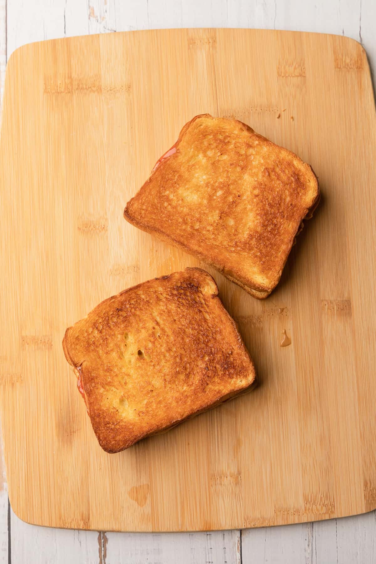 Two air fried pbj sandwiches on a cutting board.