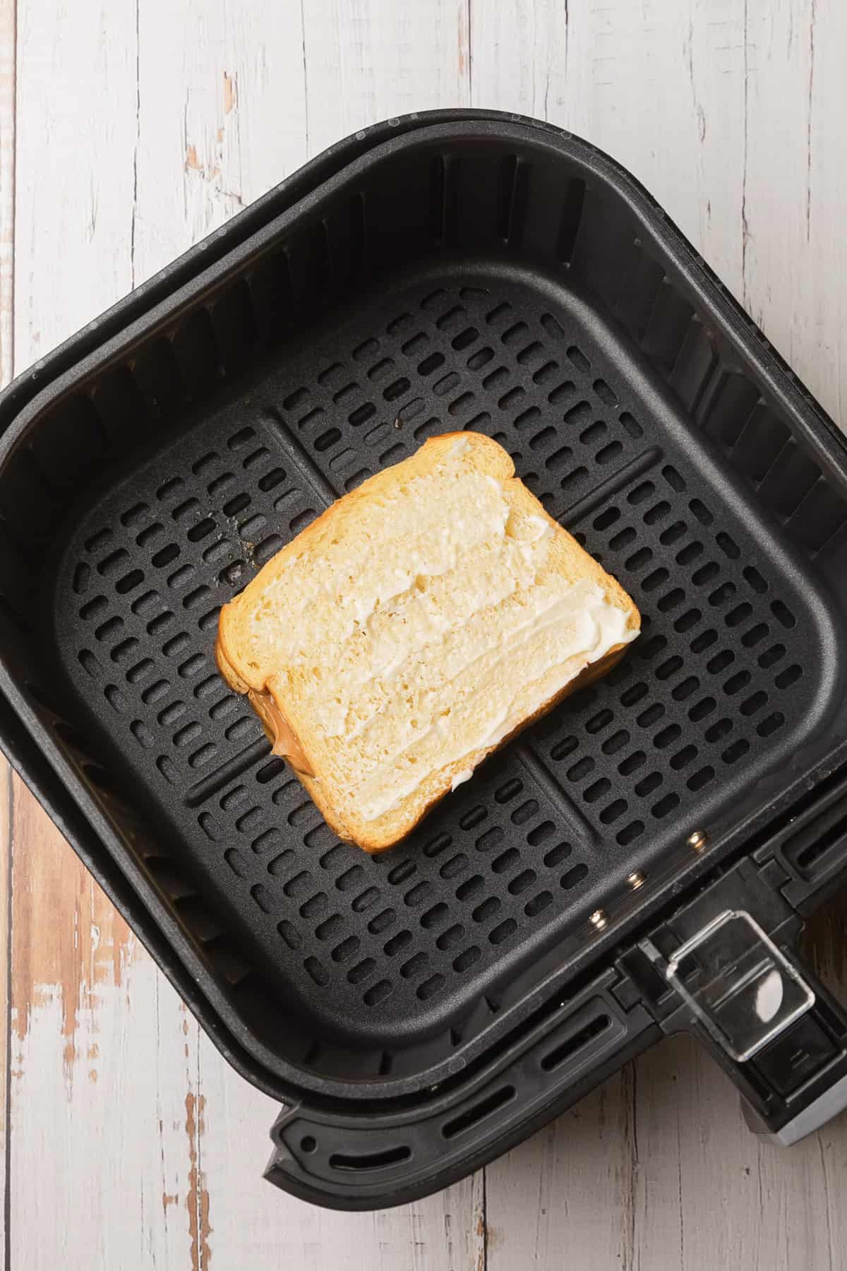 Putting the pbj in the air fryer basket.