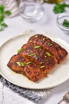 A plate of cooked marinated salmon filets.