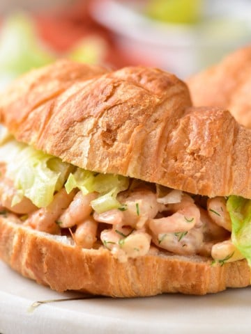 A completed shrimp salad served on a croissant.