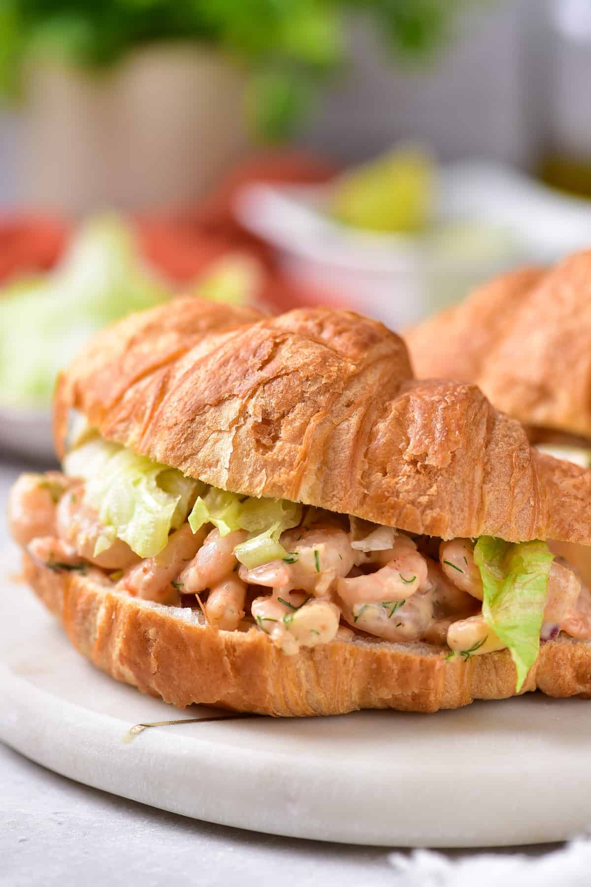 Shrimp salad dressed on a croissant.