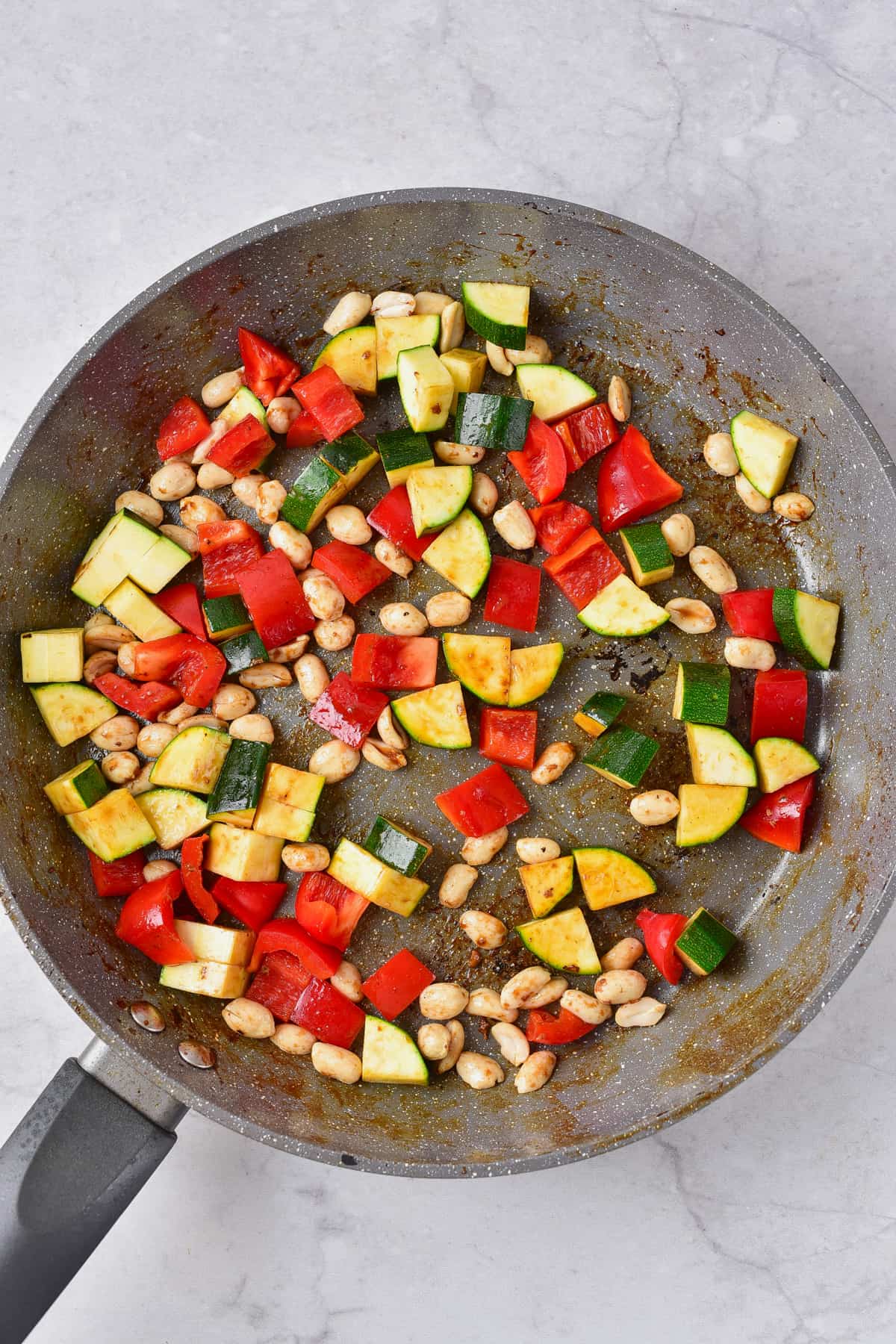 adding cut pieces of vegetables to the pan.