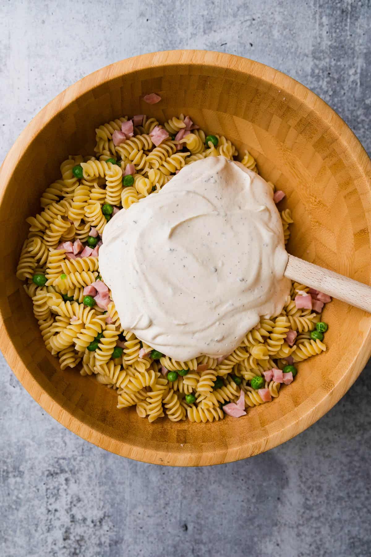 Adding a creamy dressing to the ruby tuesday ham and pea pasta salad.