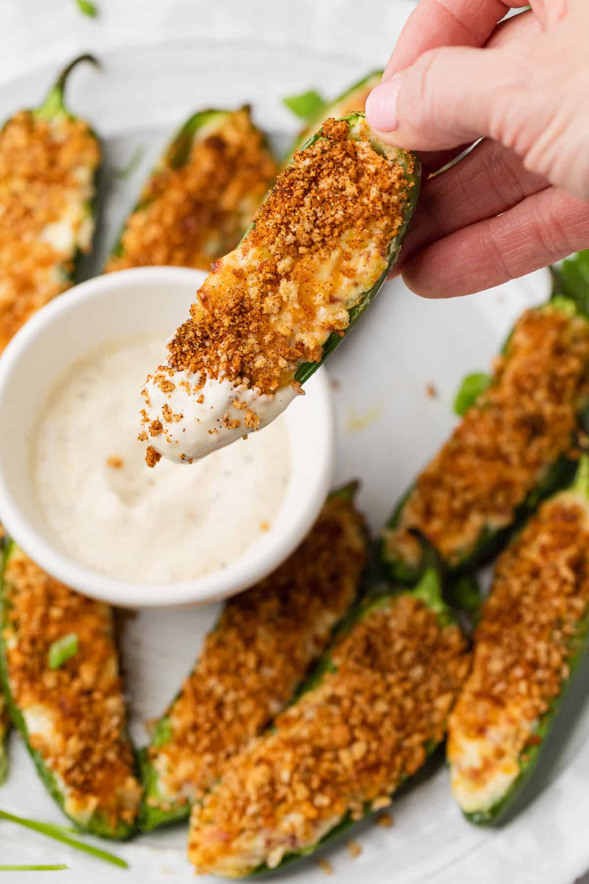 Dipping the jalapenos into ranch dressing.