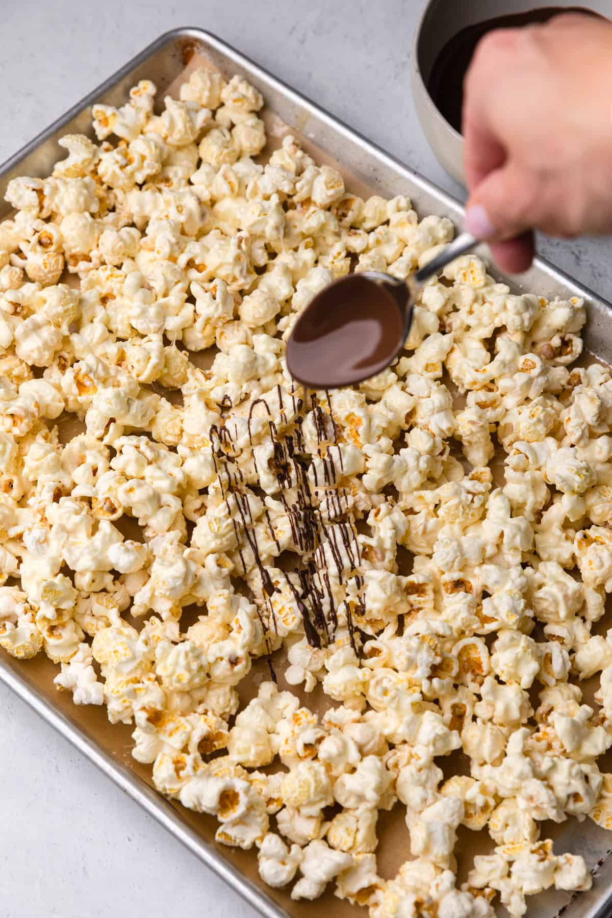 Drizzling chocolate over popcorn.