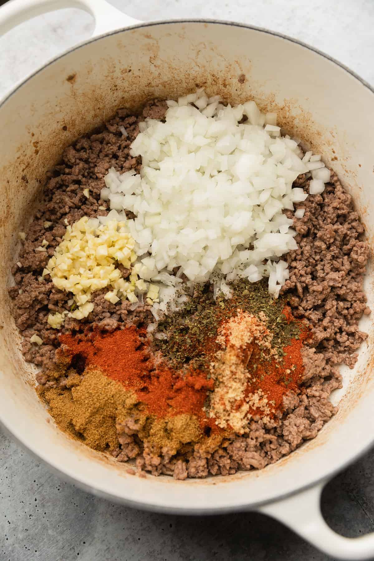 Adding onions and seasonings to pot.