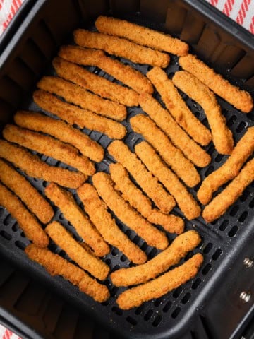 Tyson anytizers chicken fries in an air fryer basket.