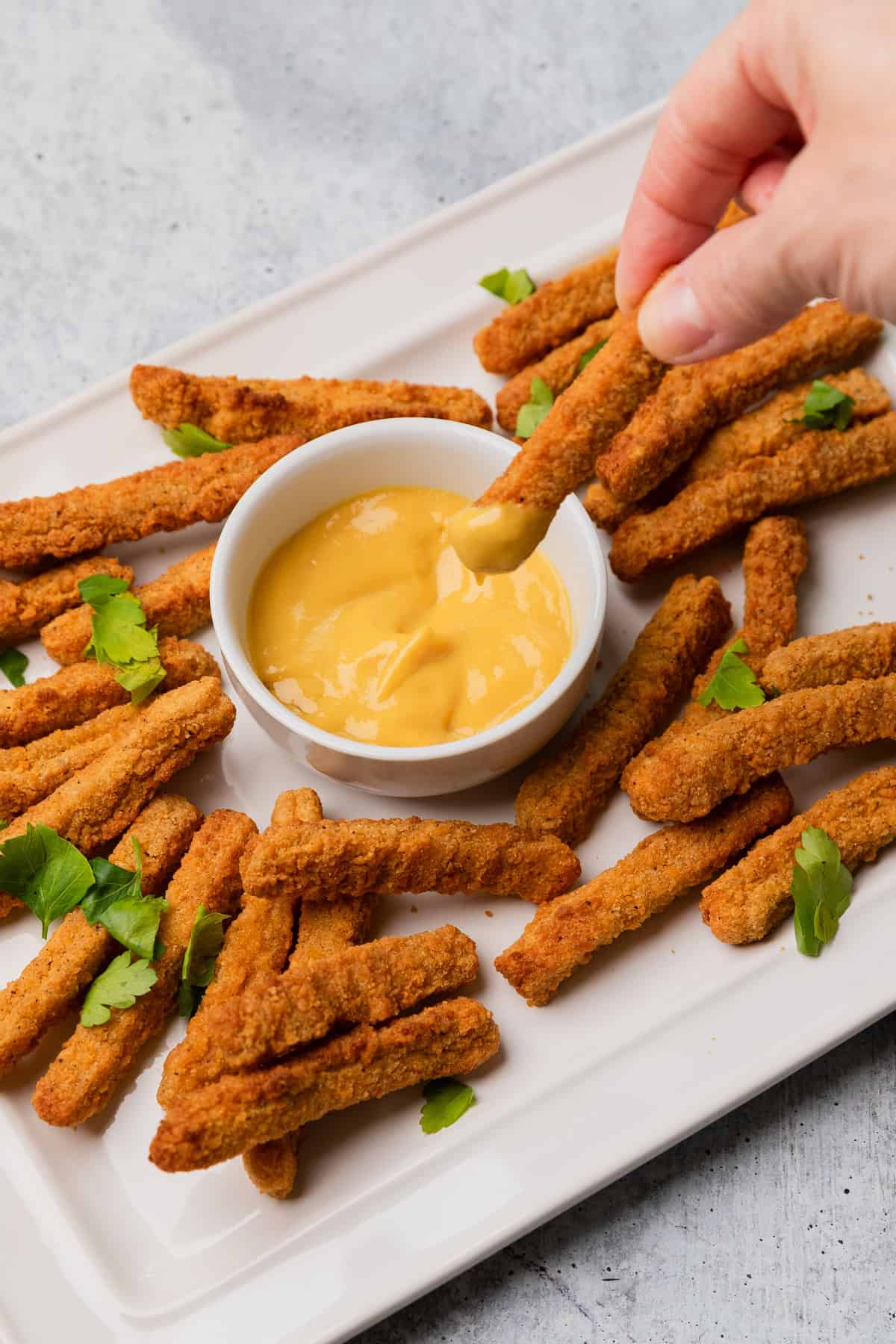 dipping chicken fries into honey mustard.