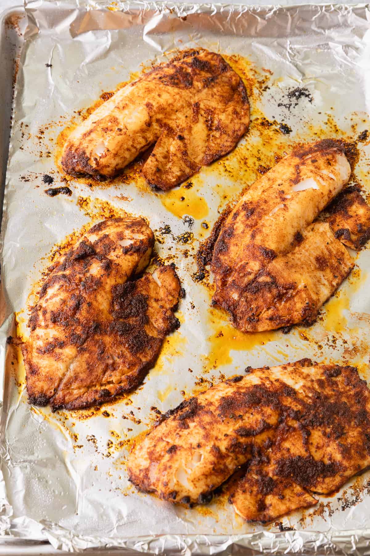 The baked blackened tilapia on a baking sheet.