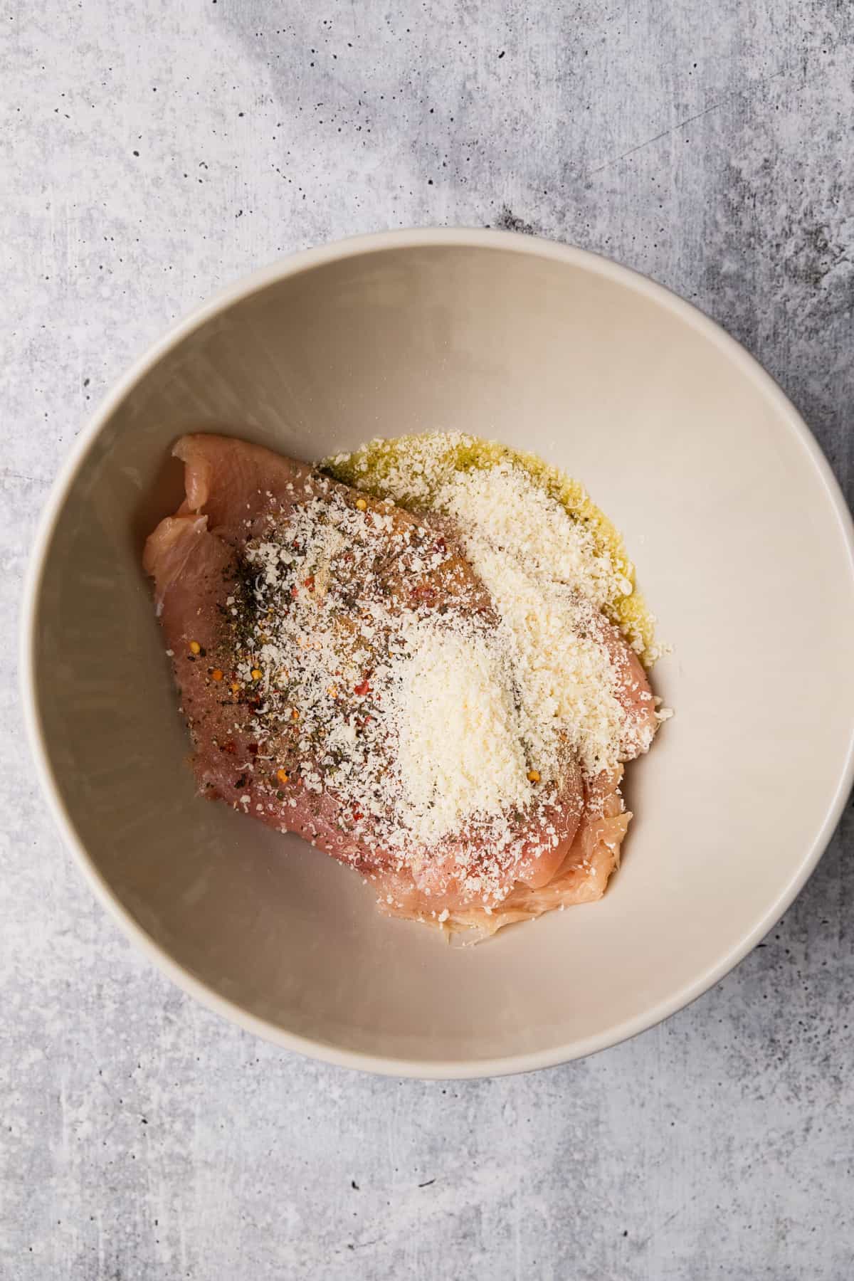 Seasoning the chicken for the recipe.