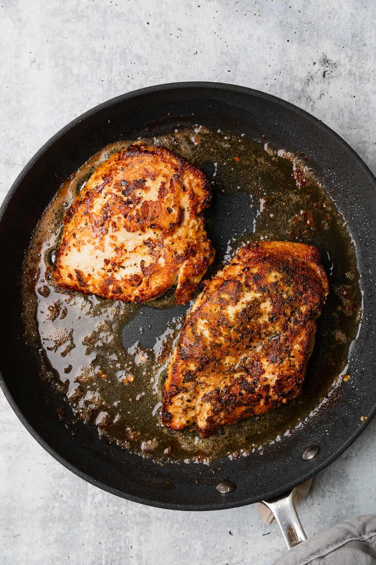 Cooking the chicken in a skillet to make the recipe.