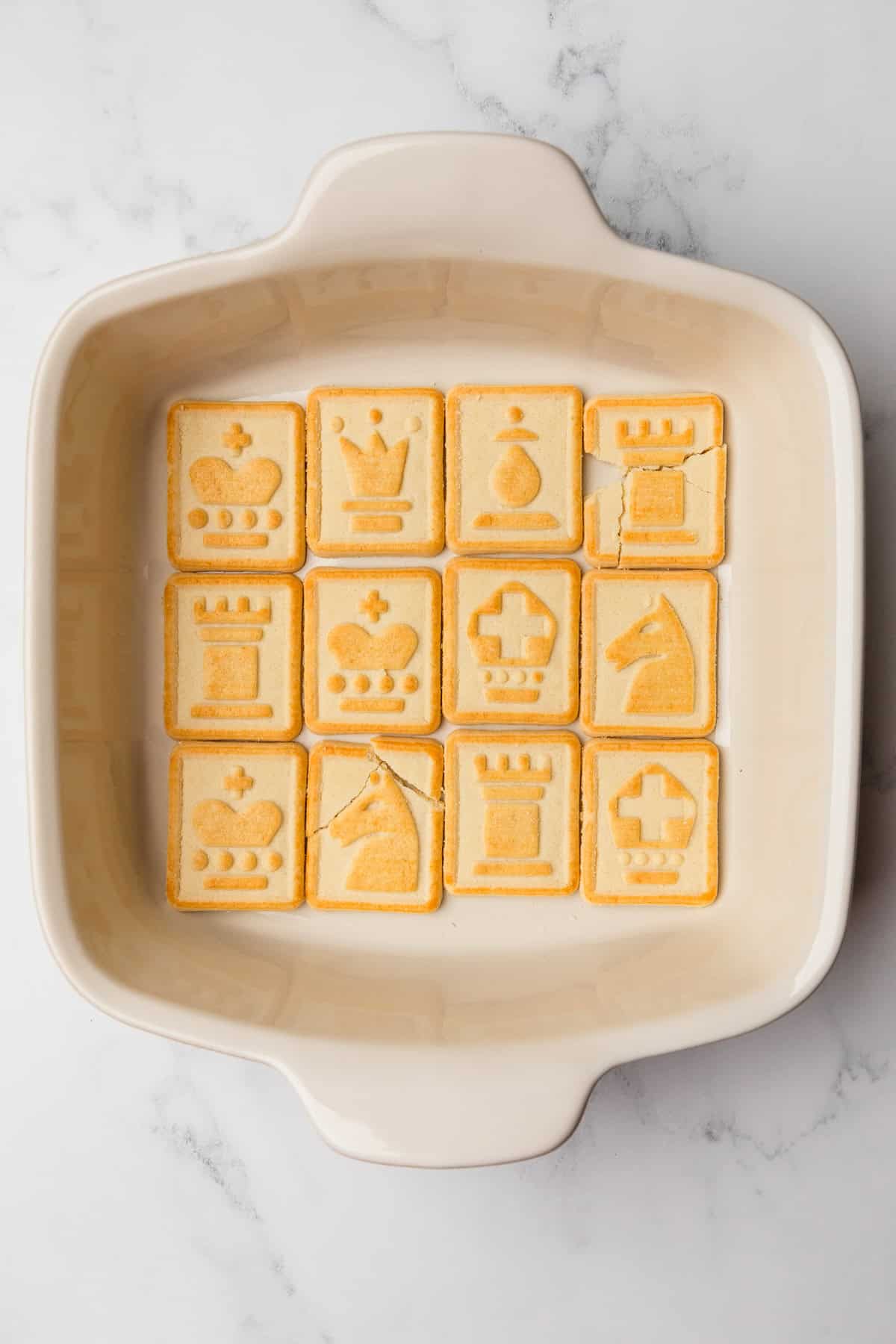 Chessman cookies lining the bottom of a baking dish.