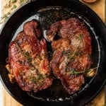 Ribeye steaks in a cast iron skillet.