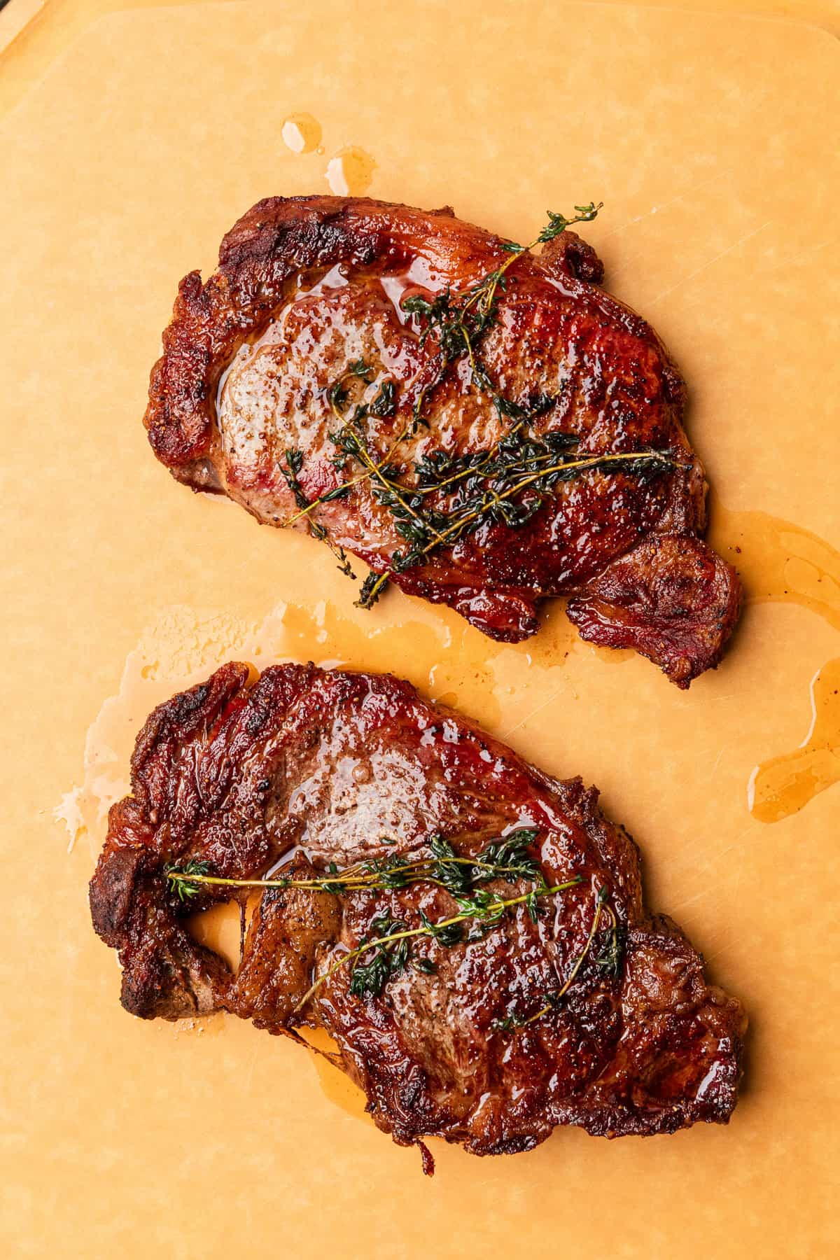 Ribeye steaks resting on a cutting board.