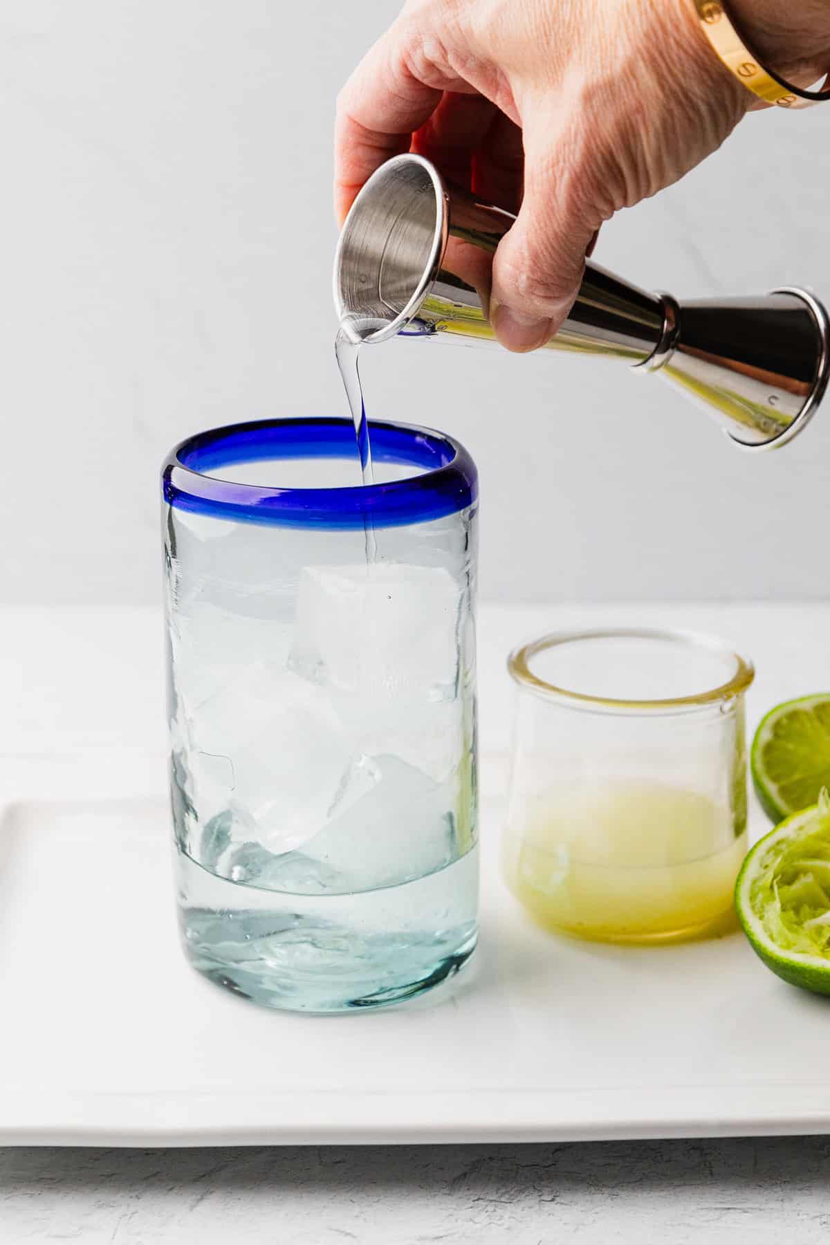 Pouring tequila into glass.