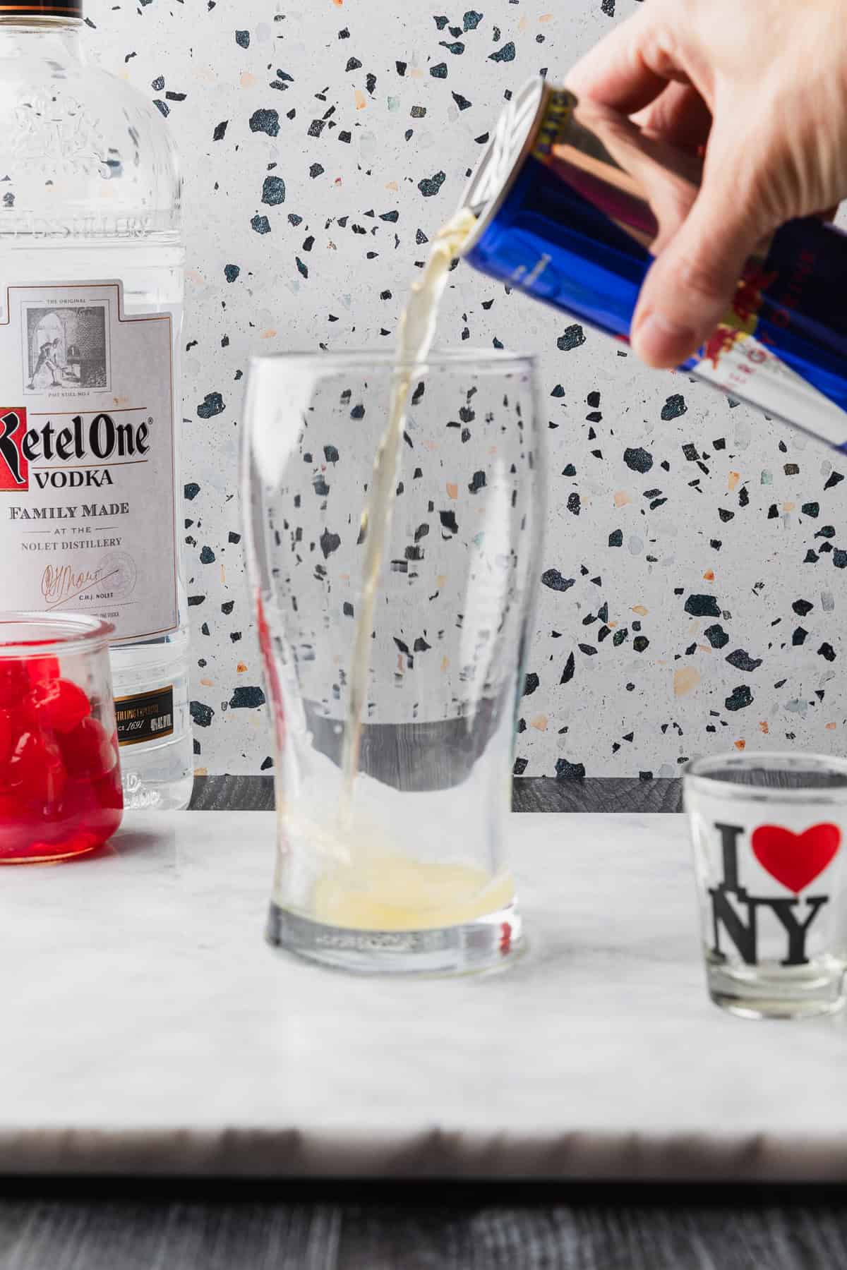 Pouring Red Bull energy drink into a bar glass.