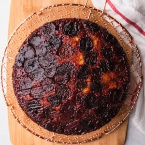 Cherry upside down cake on a cooling rack.