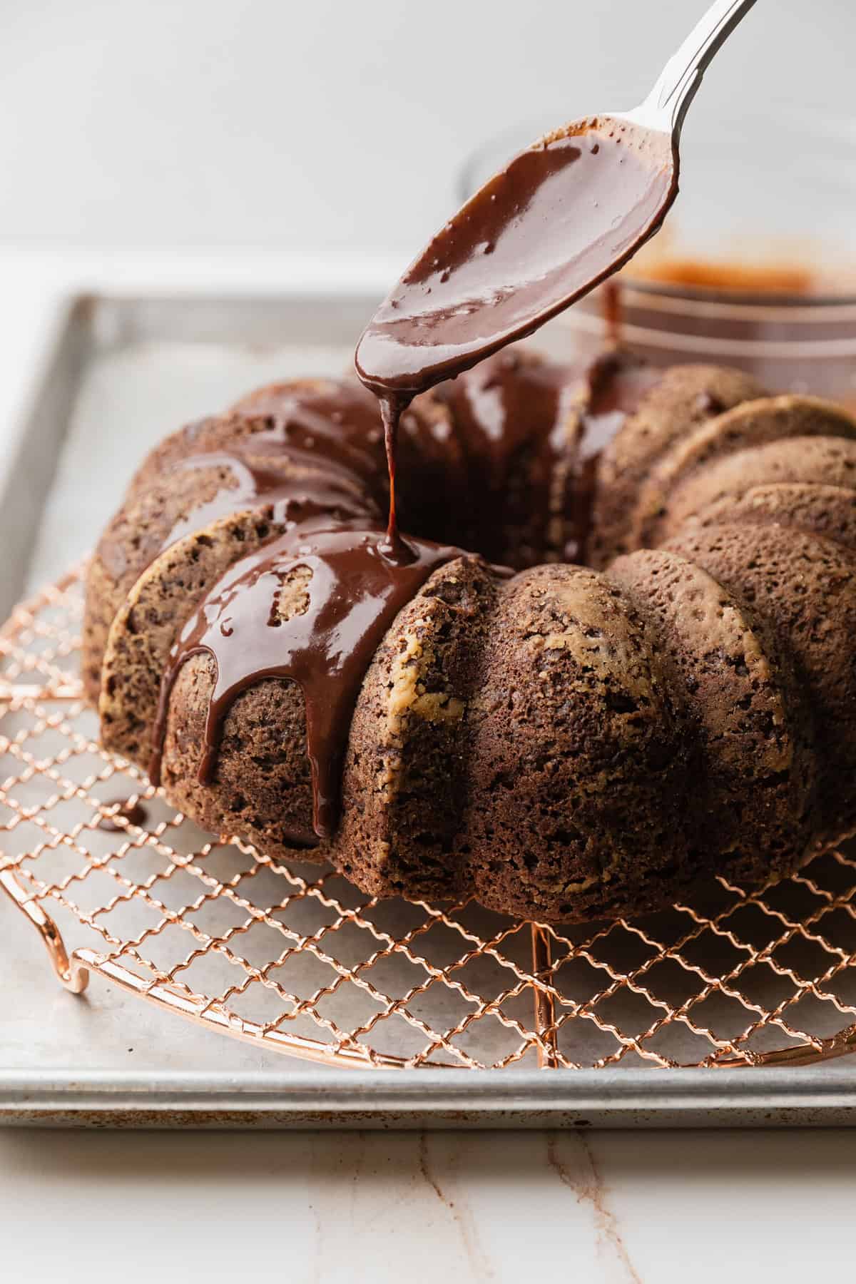 Pouring the chocolate ganache over the cake.