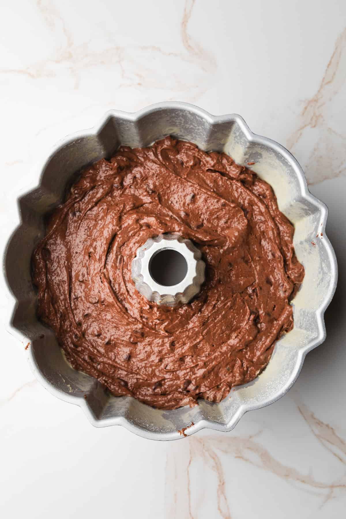 Spreading cake batter in bundt cake pan.