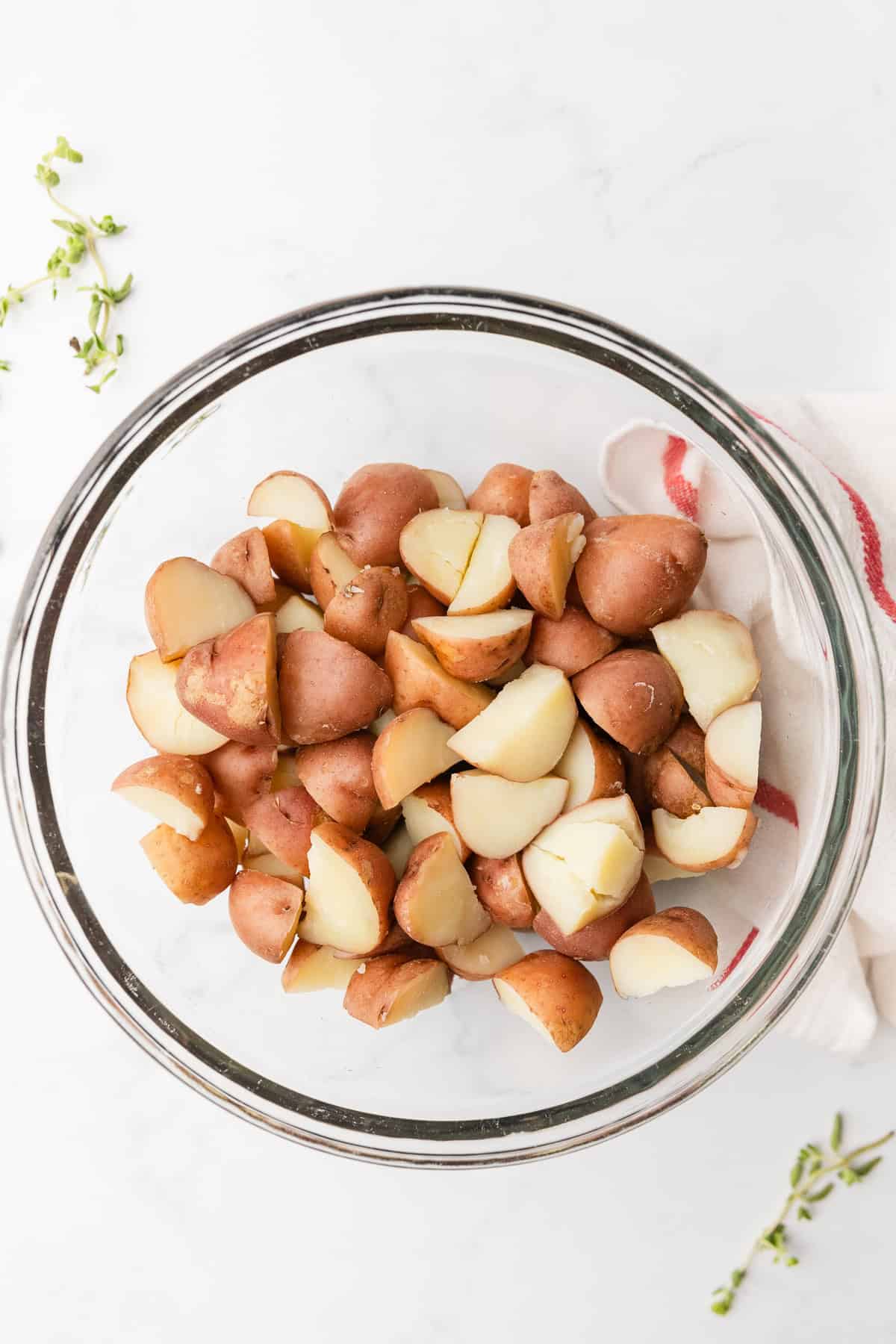 Adding cooked red potatoes to make greek pasta salad.