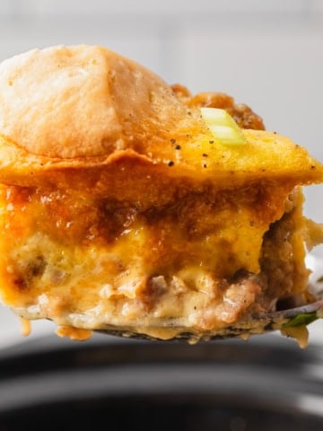 A piece of biscuits and gravy casserole over a crockpot.