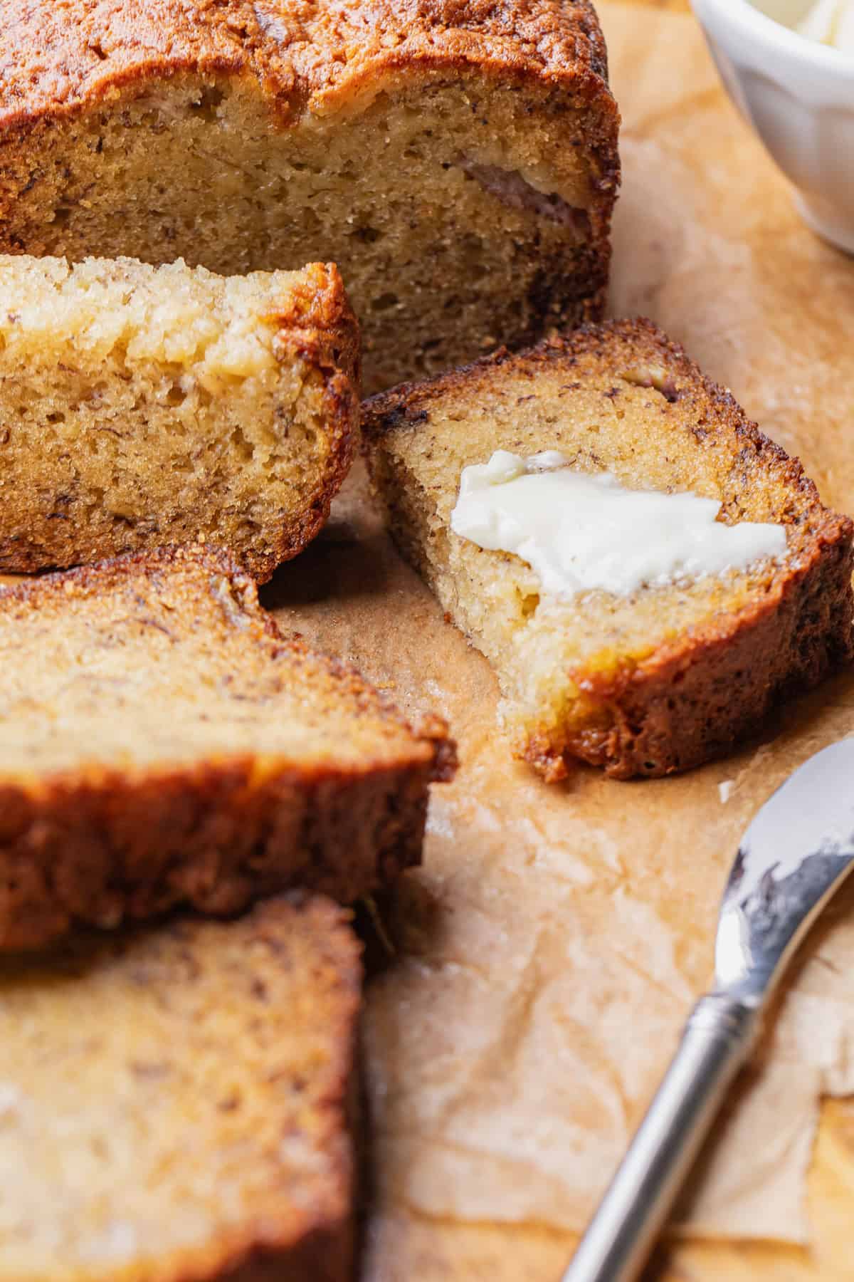 A couple slices of banana bread spread with butter.