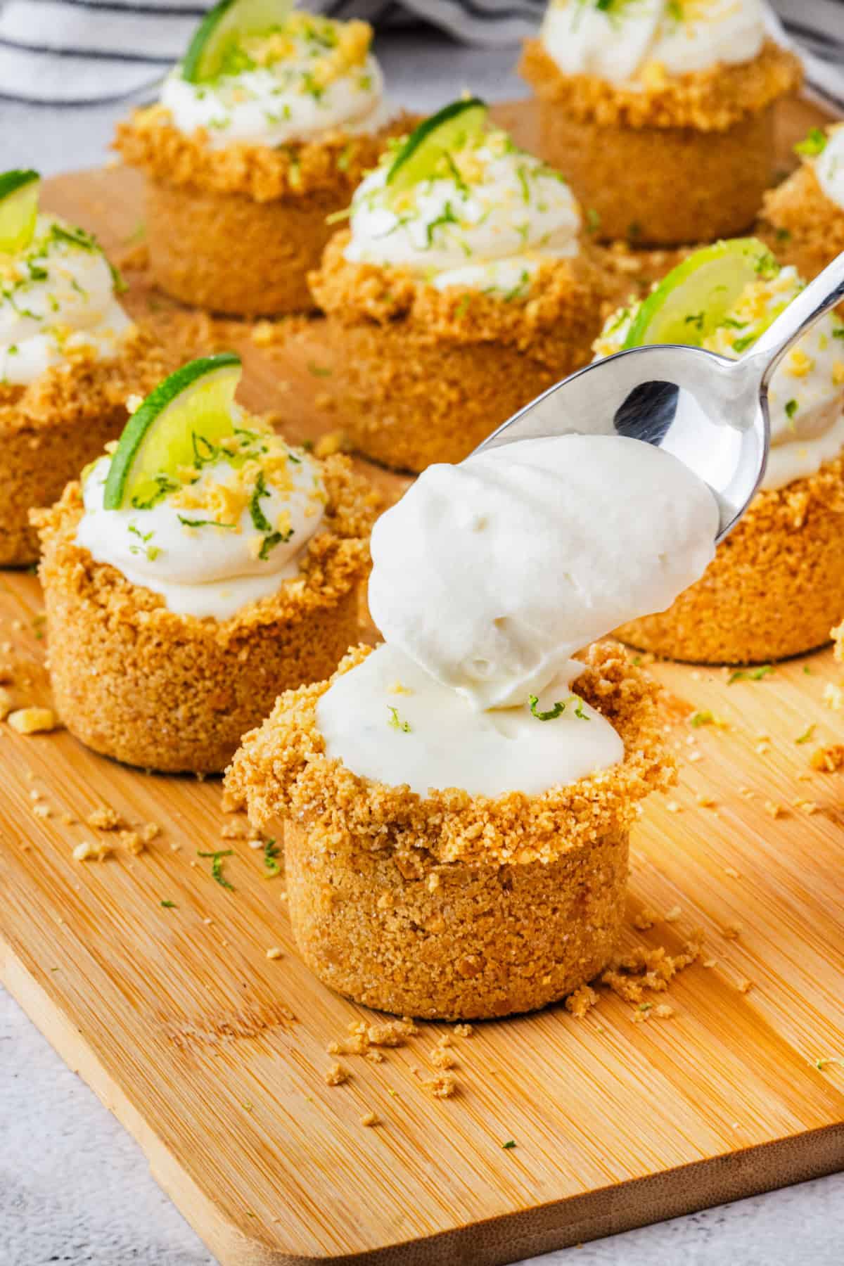 Topping the key lime pies with whipped cream.