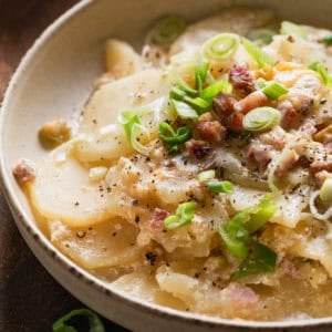 The completed recipe of scalloped potatoes and ham in a shallow bowl.