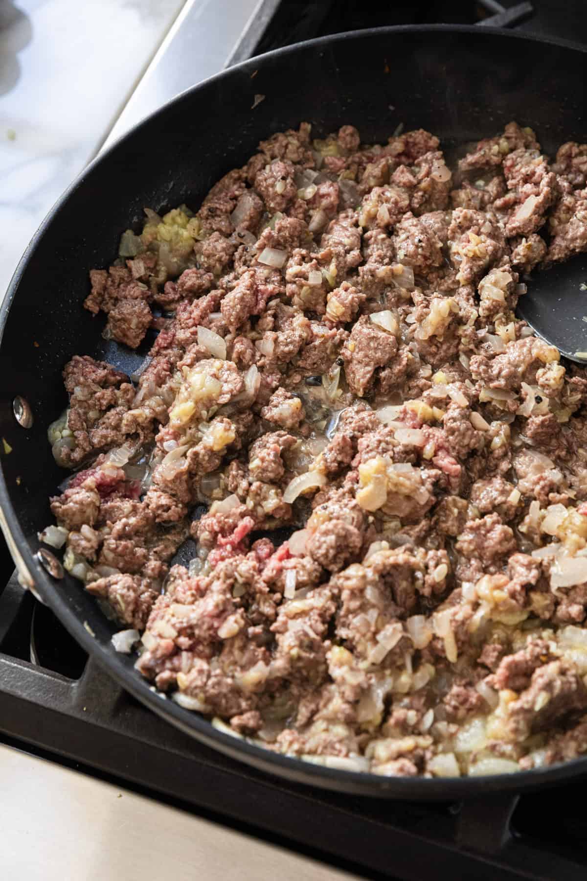 Cooking ground beef with zucchini.