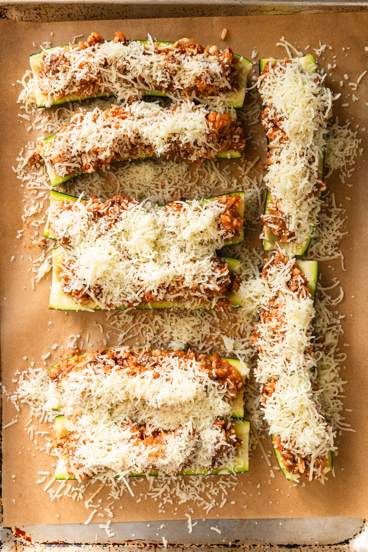 Topping stuffed zucchini with cheeses.