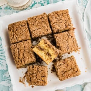 A plate of applesauce coffee cake squares with a bite taken out of one.