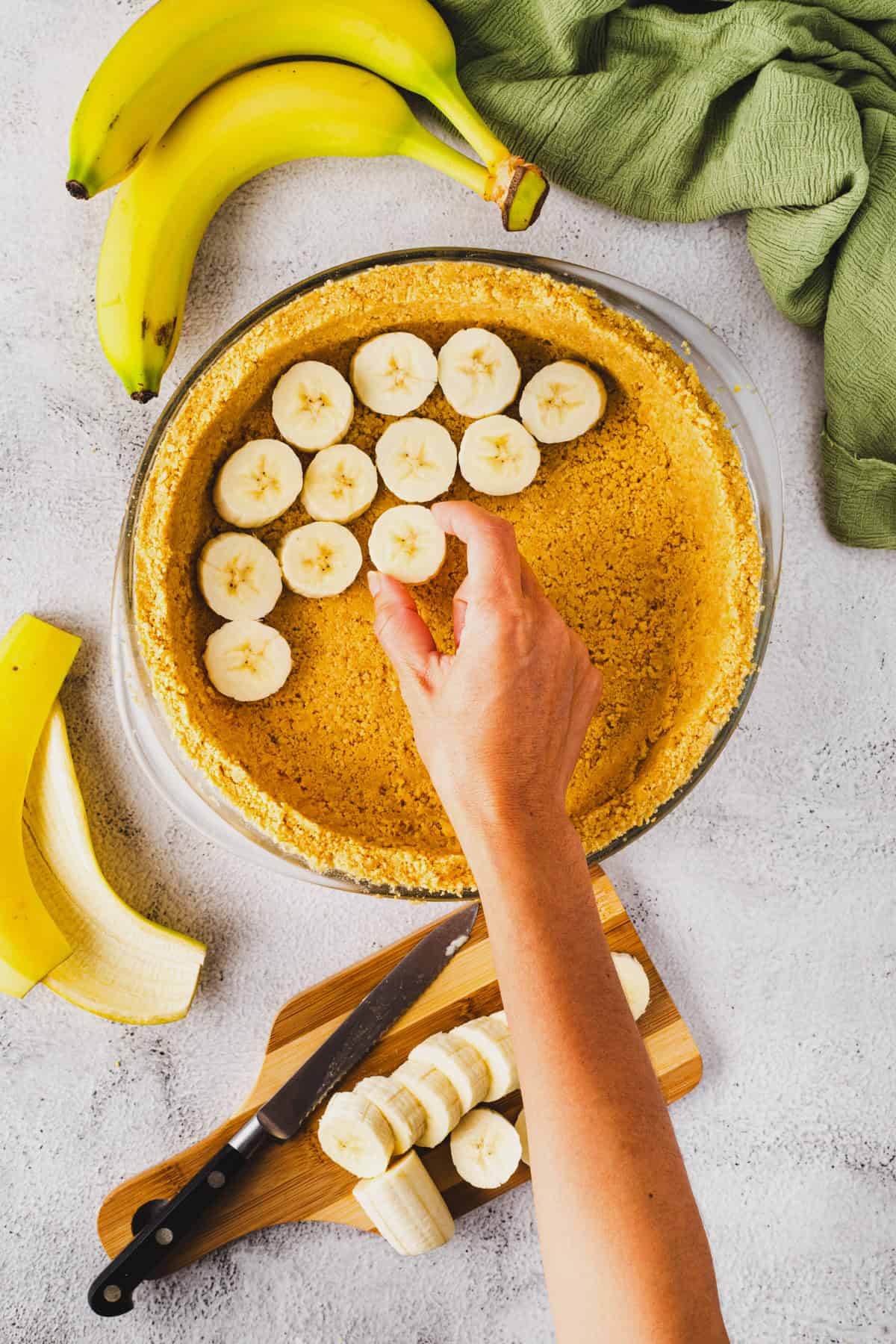 Adding banana slices to pie crust.