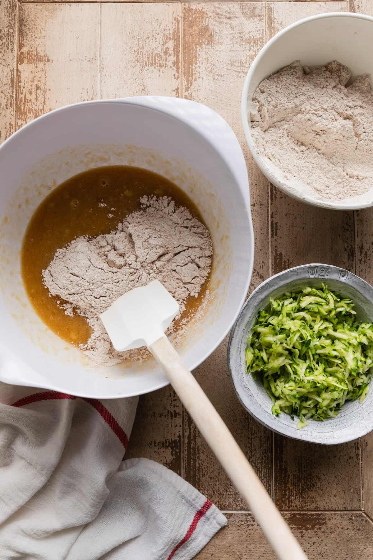 Mixing some of the dry ingredients into the wet ingredients.