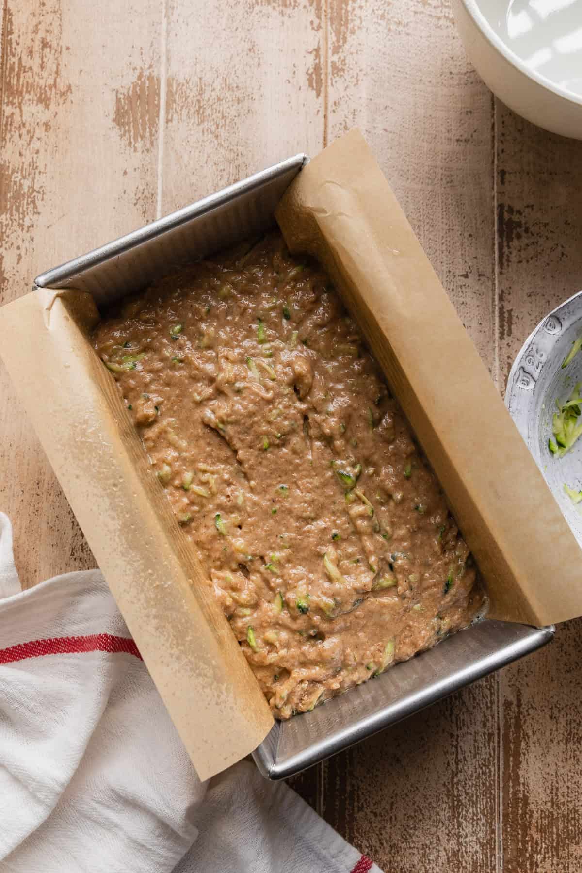 The batter in a loaf pan with parchment.