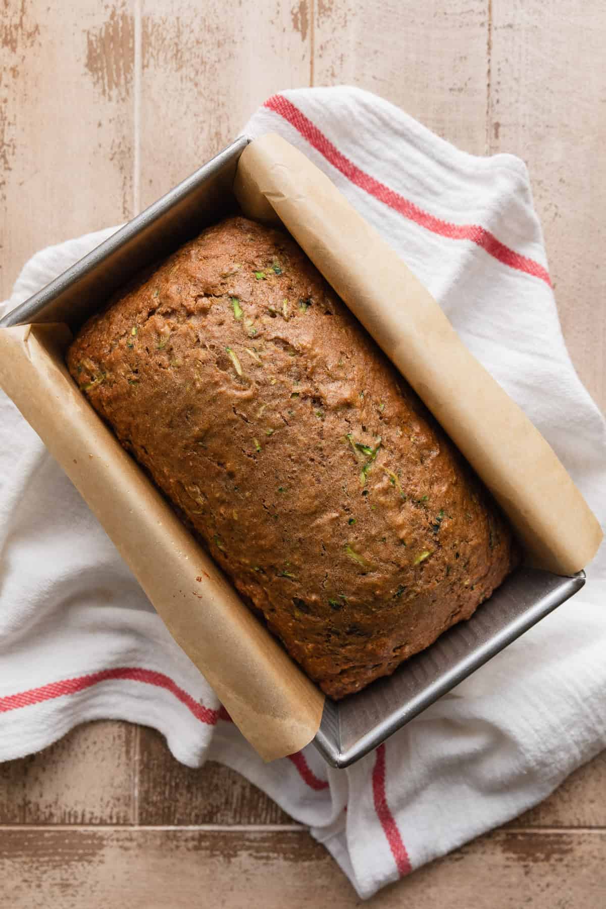 The bread baked and cooling in the loaf pan.