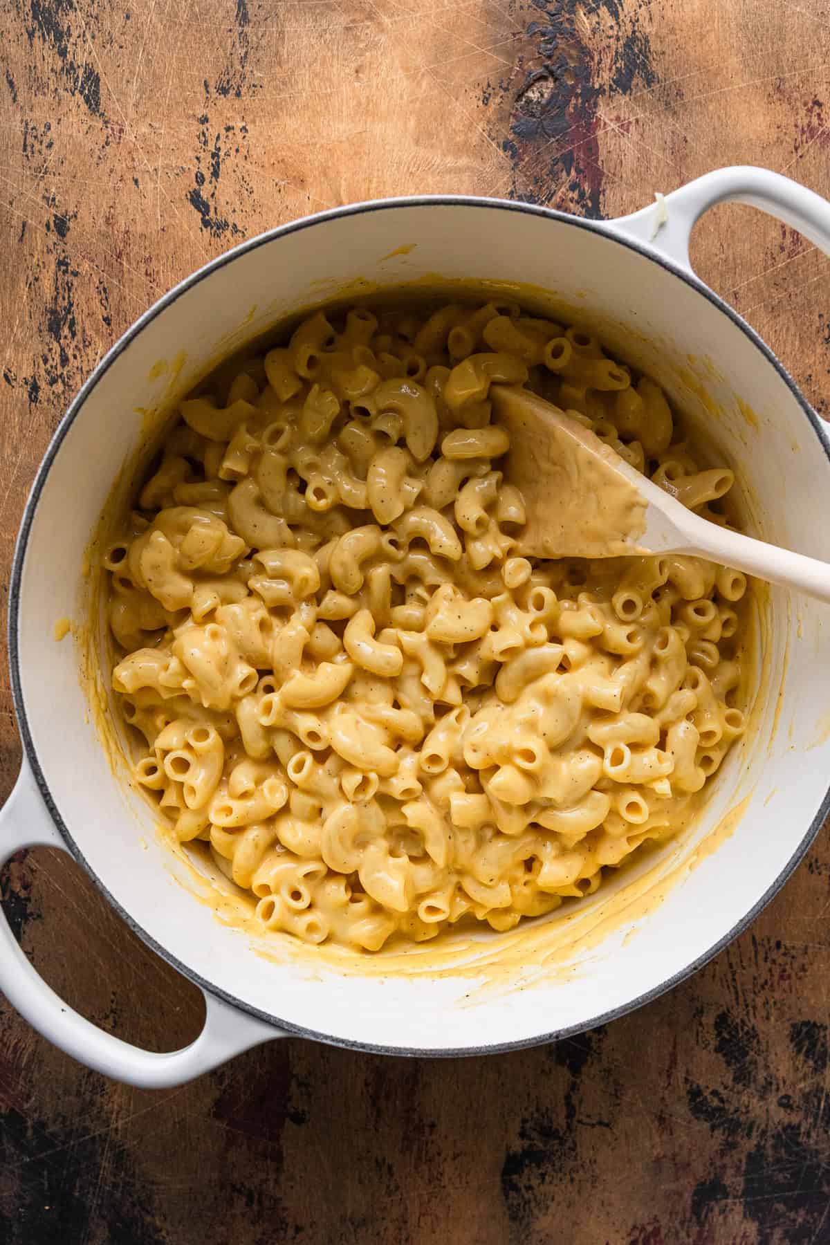 Mixing the cooked macaroni with cheese sauce.