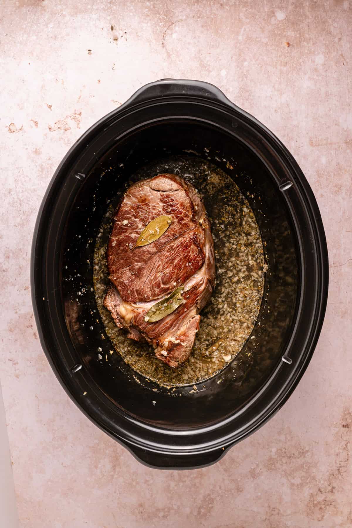 Adding chuck roast to crockpot.