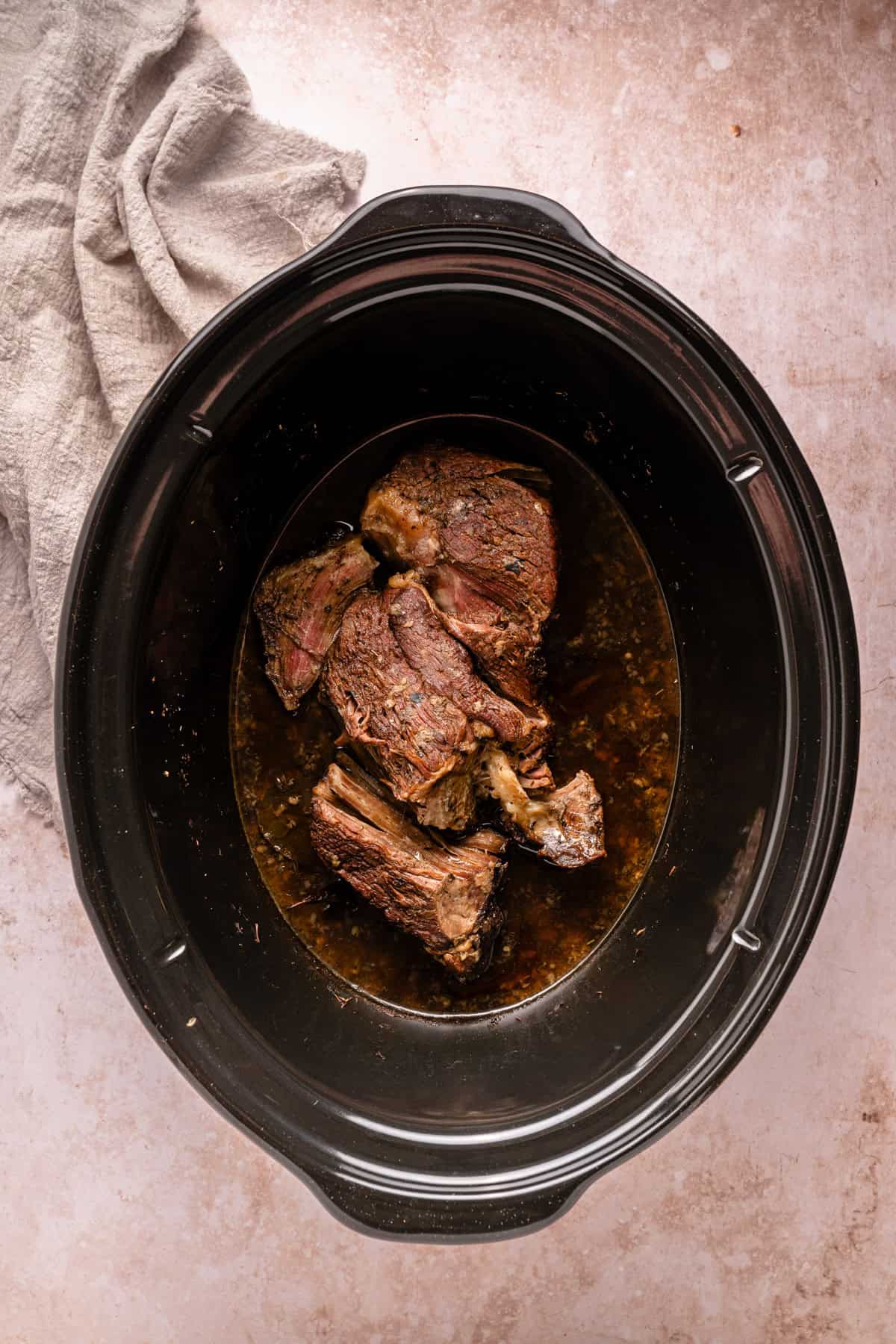 The cooked beef roast in the crockpot.