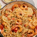 White wine seafood pasta recipe completed with lemon wedges.