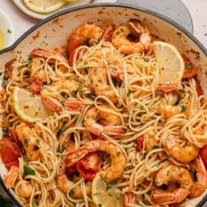 White wine seafood pasta recipe completed with lemon wedges.