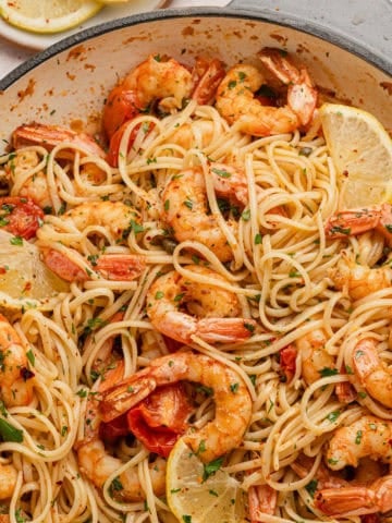 White wine seafood pasta recipe completed with lemon wedges.