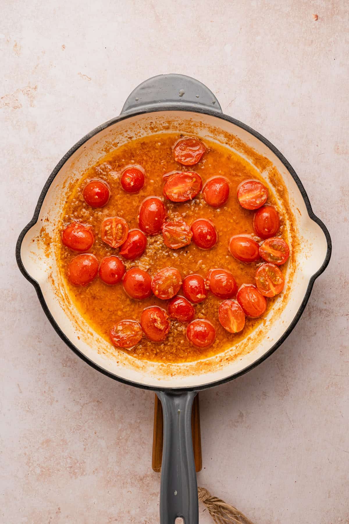 Adding tomatoes to pan.
